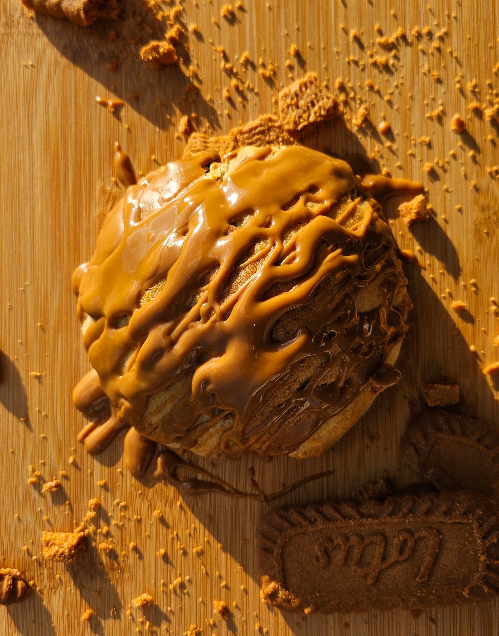 "Close-up of homemade Biscoff cookies, golden brown with a crisp finish and a hint of cinnamon. Topped with more cookie butter drizzle.