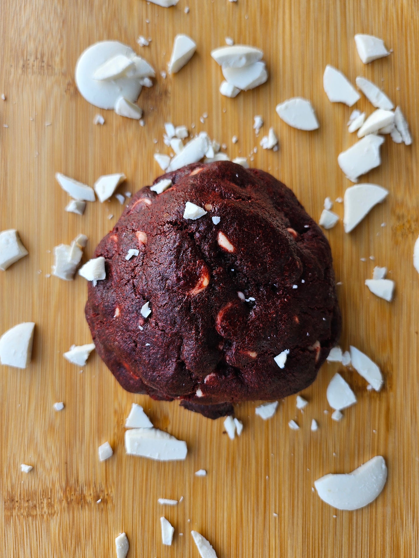 "Freshly baked red velvet cookies stuffed with a creamy cream cheese center, offering a soft and decadent bite."
