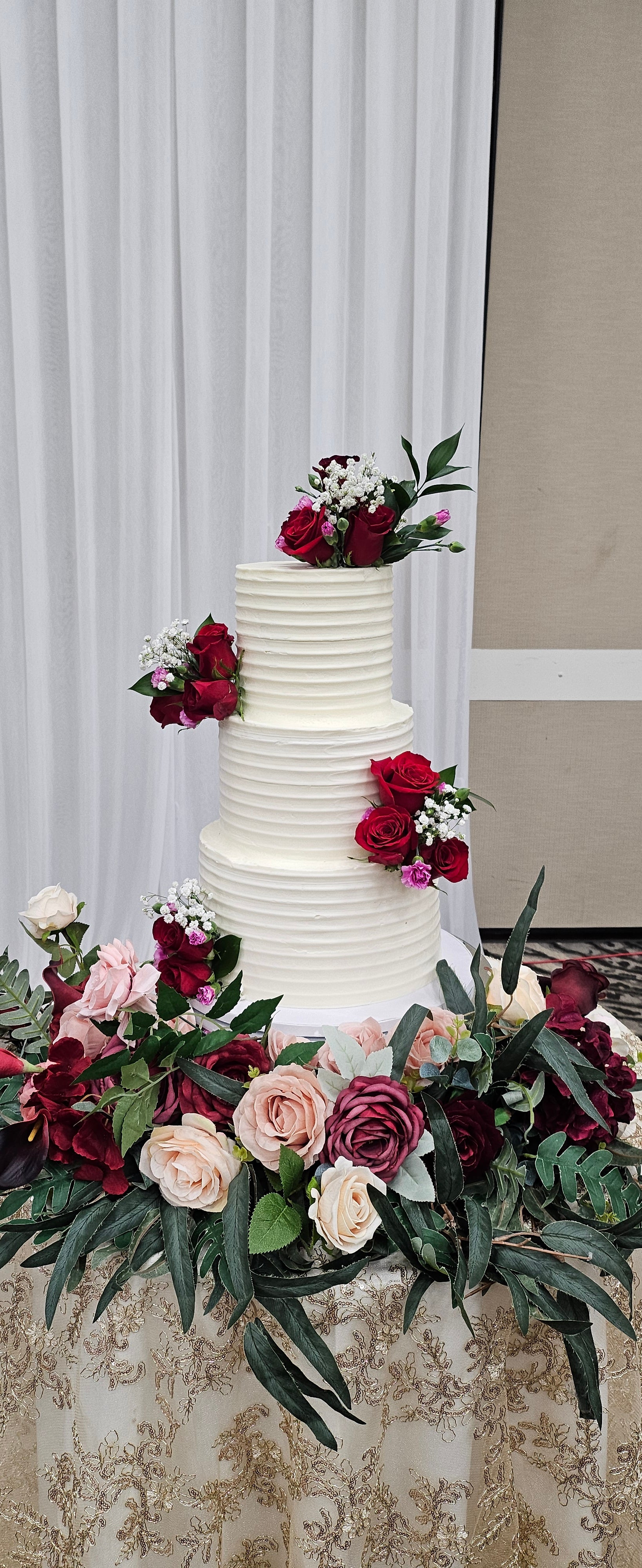 Four-tier white textured wedding cake with cascading burgundy and pink roses, Rose Hill Cakes Sanford FL